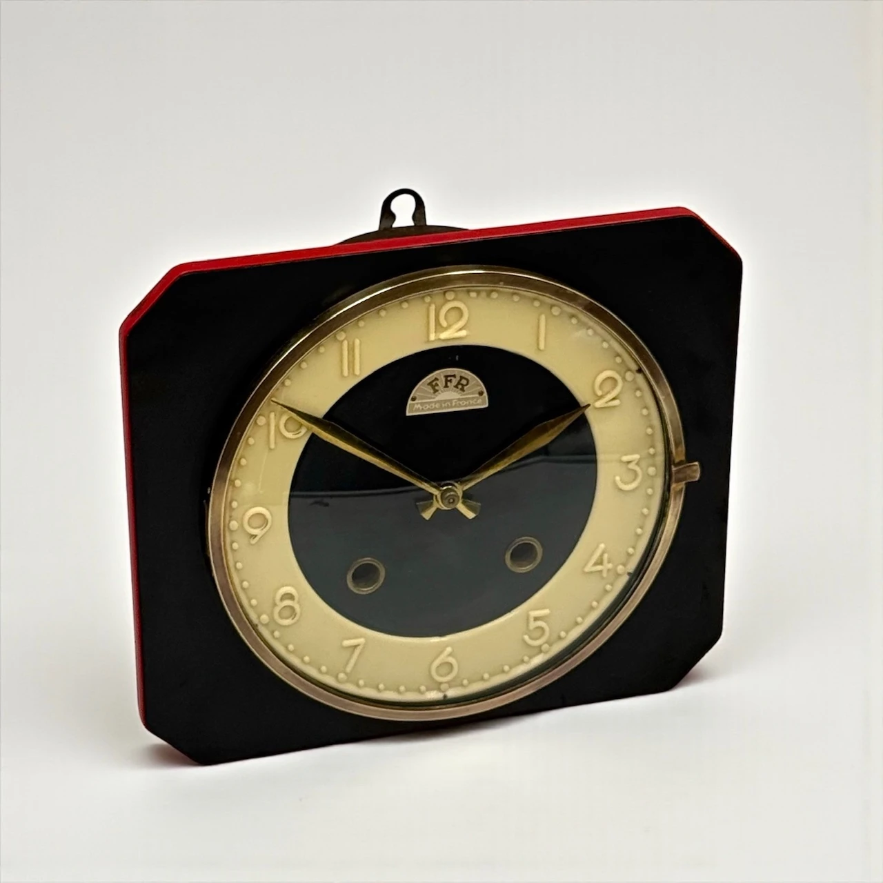 Authentic vintage French wall clock by FFR 1950s, black and ivory Formica with coral edge, brass hands, glass window and original key, Made in France